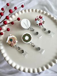 Gingerbread house, Christmas wreath, minimalist white and silver, and holiday themed badge reels. Handmade with Polymer Clay.