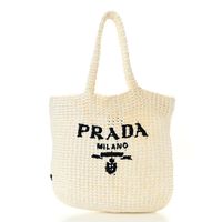 This is an authentic PRADA Yarn Raffia Effect Crochet Embroidered Small Logo Tote in White. This is uniquely structured and beautifully crafted of fine, tightly woven raffia with a black embroidered logo.