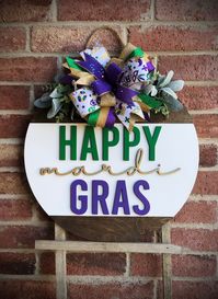 MARDI GRAS DECOR, DOOR HANGER, RUSTIC WOODEN PORCH DECOR OUTDOOR Spruce up your entryway and porch this Mardi Gras with one of our beautiful wooden door hangers! We offer a wide variety of wooden door hangers to spruce up your front door!  DOOR HANGER DETAILS * Size: 18 inches OR 22 inches;  1/2 inch thick * Includes faux greenery and bow * 3D laser cut lettering * Back is unfinished These make the perfect gift for a loved one! Whether it be a housewarming gift, wedding gift, client gift, or just for yourself for your home... we have you covered! This beautiful Happy Mardi Gras Decor Door Hanger is one of a kind!  Each piece of wood is hand picked, hand cut, stained and/or painted. Due to the nature of wood, each piece is unique in its own way. Each piece of wood may take stain differently