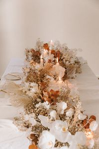 We wanted to create a table centerpiece with dried and fresh flower that had an Autumn wedding feel to it without going overboard on the darker tones--maintaining the lightness we love about weddings. Photos by Lara Onac.