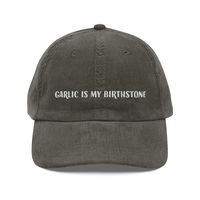 Show off your love for garlic with our one-of-a-kind corduroy cap! Crafted from soft, vintage-inspired corduroy, this hat is both stylish and comfortable. The embroidered "Garlic is My Birthstone" slogan adds a touch of quirky charm to your look. Featuring an adjustable strap for a perfect fit and a classic 6-panel design, this cap is perfect for any occasion. Whether you're running errands or attending a festival, you'll be turning heads in style.    Join the garlic-loving community and make a