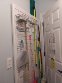 Since I don't have a utility closet, this peg board holds cleaning tools snugly behind my laundry room door in the 4 inches space.  And it looks nice too!  Made it myself for about $30.