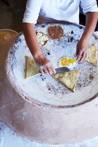 Ground native corn is used to create masa-based appetizers and street food, including tlayudas and tetelas topped or filled with refried beans and cheese at Itanoní Tortillería y Antojería.