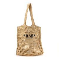 This is an authentic PRADA Yarn Raffia Effect Crochet Logo Embroidered Tote Bag in Naturale. This stylish woven tote is crafted of natural color raffia. The bag features a black Prada on the front and an unlined interior.