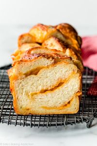 It's surprisingly easy to make homemade cheese bread from scratch. This soft buttery yeasted bread is twisted up with your favorite cheddar or other variety of cheese and baked in a loaf pan. Recipe on sallysbakingaddiction.com