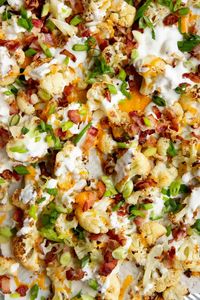 Tender, caramelized roasted cauliflower is loaded with tangy ranch, crisp bacon, fresh green onions, and sharp cheddar cheese for an addicting side dish! #roastedcauliflower #loadedcauliflower