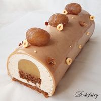 Cette bûche se compose d'un pain de gênes éclats de marrons glacés cacao noisette, d'une mousse à la crème de marron, d'une gelée de poire, d'un croustillant praliné et d'un glaçage chocolat lait/chocolat blanc à la pâte de praliné noisette. En décoration...