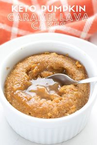 Sugar free caramel oozing out of a keto pumpkin caramel lava cake, with an orange napkin in the background.