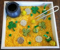 "This St. Patrick's themed sensory basket is fantastic for young creative minds!  This work is fantastic for refining fine motor skills and allowing creative exploration.  Great for a Montessori Classroom or Home Daycare environment. Materials Included: - Wooden Box (9\"x9\") - Pot-Of-Gold Collection Bowl - Bamboo Tweezers - Filled with: 1 lb yellow colored rice and a variety of shamrocks, pom poms, bells, and coins  Suggestions for use:  - Place this work in a place for your child/children to easily access  - Let them explore without any directions Important Information: - Recommended for children ages 3+ as there are small parts.  If using with young children please keep a close eye on them."