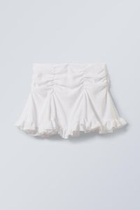 A short mini skirt made from a soft viscose fabric enhanced with a touch of polyamide. It has gathered seam detailing, an invisible side zip with hook and bar closure, inserts for added dimension, and a frilled bottom hemline.