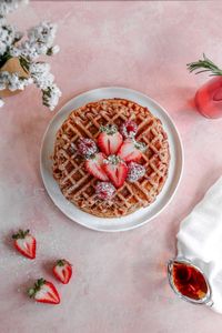 Crispy on the outside, chewy on the inside, these waffles are bursting with strawberry flavor and are a perfect way to treat mom on Mothers Day! Learn how to make strawberry waffles from scratch for this easy breakfast recipe!  #RecipesForOne #MothersDayRecipes #BreakfastRecipes #FrostingandFettuccine