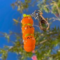 Ya like oranges? How about three! This orange keychain is guaranteed to bring a smile anywhere you go, each orange sporting its own unique personality!  Each keychain is made with durability in mind. They are handmade using polymer clay, and then painted with gouache before finally being coated in a glossy layer of polyurethane :)   Please note!  - Due to the handmade quality of each item, there will be some inconsistencies between pieces. This will NOT take away from the care and quality of eac