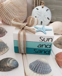 "Who is ready for the beach This mini book stack will surely have you wishing for warm sand between your toes. This adorable stack is painted in the perfect coastal shades. A natural jute ribbon is tied and topped with a bow. On top adorns a starfish. All of our books are custom made with reclaimed lumber. We take pride in delivering a quality product. Our wood blocks are sanded several times and coated twice with premium acrylic paints. All of our book stacks are bond together with glue. The le