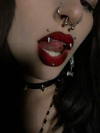 angel bites / angel fangs / labret piercing / high nostril piercings septum / black and red lipstick / hatchet earring / spiked choker / chainmail earring