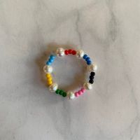 Rainbow and pearl beaded ring on an elastic string. All beads used are unique, so each ring is unique! *If you have concerns about sizing, please message me!