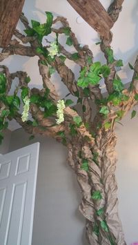 Paper tree with leaves, flowers and leaves. All you need is a brown paper roll, staple gun, stapler, artificial leaves and flowers and a bit of imagination!!!