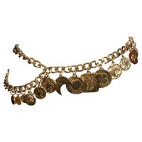 Very rare gilt charm belt designed by Yves Saint Laurent dating to the early 1990's. This fabulous belt features 16 coin charms suspended from a 37" linked chain from end to end which can be worn a few different ways including a necklace if you are creative. Charms include a heart, moon, star, clover, bird, fleur-de-lis, and large 'YSL' rectangular piece at center front. Belt as shown on a 24" waist. Very impressive belt. Good condition.