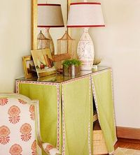 If your home lacks an entry closet or foyer, place a small shelving unit against the wall of your living or family room, cover it with a pretty divided skirt and top with piece of glass for easy cleaning. The hidden storage space can conceal shoes, boots, games, and baskets for hats, gloves, and scarves.