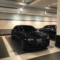 two black rolls royces parked in a parking garage