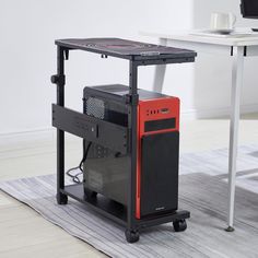 a computer tower sitting on top of a rug in front of a desk with a laptop