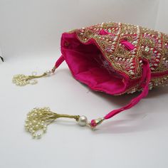 rani pink fabric pearl beaded the shining handbag drawstring purse potli bag for woman | indian wedding purse and potli gifting giveaways Designed with the heart, this beautiful Potli or batawa bag are eye catchy and made of premium material. Key Features: Embroidery art work This potli is good match with both Indian and western outfits and are superb for wedding and festive parties This would be best complement to your designer saree, lenhga or any other kind of dress This is the combination of Festive Pink Potli Bag For Party, Pink Shoulder Bag With Handwork For Party, Elegant Pink Shoulder Bag For Festivals, Pink Zari Work Potli Bag For Party, Pink Handwork Pouch Bag, Elegant Pink Handmade Potli Bag, Diwali Wedding Bag With Mirror Work, Festive Pink Handcrafted Shoulder Bag, Festive Pink Embroidered Shoulder Bag