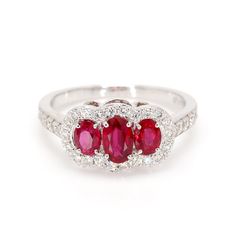 Classic ruby 3-stone ring in 14 karat white gold. This ring is prong set with three 1.30cttw red oval shaped ruby corundum, and 42 diamonds weighing 0.52cttw. Ring Size 7. Ruby Is The Birth Stone For July. Oval Red Ruby Ring With Three Stones, Classic Red Three Stone Rings, Classic Red Three Stone Diamond Ring, Classic Red Three-stone Ring, Red Three Stone Round Cut Ruby Ring, Red Three Stone Ruby Ring, Red Three-stone Ruby Ring, Red Ruby Three Stone Round Cut Ring, Fine Jewelry Red Ruby Three Stone Ring