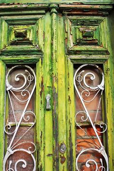 an old green door with wrought iron work