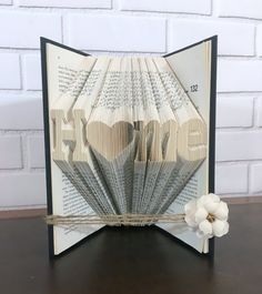 an open book with folded pages and flowers