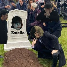 a group of people standing around a tombstone with a woman's face on it