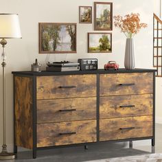 a dresser with drawers and pictures on the wall