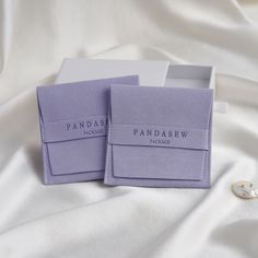 two purple business cards sitting on top of a white sheet