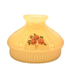 a yellow glass vase with flowers painted on the front and bottom, sitting on a white surface