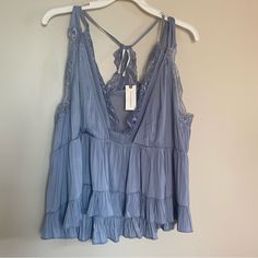 New With Tags. In Excellent Condition With No Flaws. Sleeveless. Lace Trim. Ruffle. Babydoll. Satin. Lightweight. Boho. Coastal Cowgirl. Versatile. Night Out. Party. Loose Fit. Relaxed Fit. Preppy. Cottagecore. Blue Tops With Lace Trim For Vacation, Blue Ruffled Top With Spaghetti Straps, Blue Spaghetti Strap Top With Ruffles, Blue Ruffled Spaghetti Strap Top, Ruffled V-neck Camisole For Vacation, Spring Blue Camisole With Ruffles, Blue Ruffled Sleeveless Camisole, Blue Ruffled Camisole For Spring, Blue Feminine Tops With Lace Trim