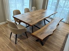 a dining room table with two benches in front of it and some chairs around it