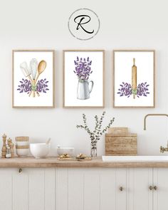 three framed art prints on the wall above a kitchen counter with dishes and utensils