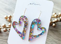 Pastel Chunky Confetti, Mod Heart Glitter Earrings  These glitter mod heart earrings are the perfect addition to your Valentine's day outfit! Acrylic Earrings with a stainless steel hook.  The exact look of the glitter will vary from earring to earring as we cut them from one large sheet of acrylic.  The photos are a sample and the pair you receive will be very similar in look. Heart-shaped Earrings For Mother's Day Party, Heart Earrings For Mother's Day Party, Mother's Day Heart Earrings For Party, Trendy Party Heart Earrings With Heart Charm, Open Heart Earrings With Heart Charm For Party, Mother's Day Double Heart Earrings For Party, Party Open Heart Earrings, Silver Heart Earrings For Mother's Day Party, Silver Heart Earrings For Party On Mother's Day