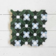 a green and white tile design on the wall