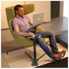 a man sitting in a chair using a laptop computer