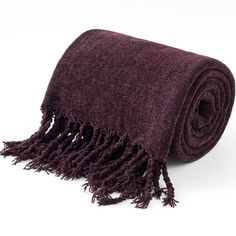 a dark purple blanket with fringes on the bottom and one end rolled up to show it