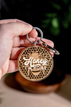 a person holding a keychain that says honey i'm home