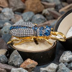 This exquisite silver topped, yellow gold beetle brooch/pendant features a total of five (5) oval mixed cut rubies and twelve (12) round mixed cut rubies in silver prong and bead settings. The head and wings are bead set with a total of one hundred thirty-two (132) rose cut diamonds. The brooch/pendant measures 53.8mm long by 29.0mm wide and 8.9mm deep, finished with a bail and hinged and locking pin back. Fine Jewelry Multi-stone Yellow Gold Brooches, Fine Jewelry Yellow Gold Multi-stone Brooches, Heirloom Oval Gemstone Brooches, Oval Yellow Gold Brooches With Gemstone, Fine Jewelry Diamond Multi-stone Brooch, Fine Jewelry Diamond Multi-stone Brooches, Diamond Multi-stone Brooches In Fine Jewelry Style, Multi-stone Diamond Brooches, Antique Oval Diamond Brooch