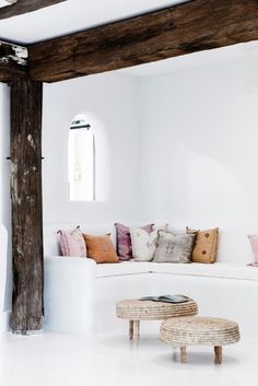 a living room with a white couch and some pillows on the back of the couch