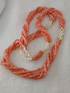 This mid-century multi-strand necklace is a beautiful combination of natural coral and Kashi (river) pearls. The five-strand necklace contrasts the pink coral with luminescent river pearls and 14k yellow gold beads. The long 32-inch length easily slips on for a seamless design. A large, carved coral bead with an Asian motif is the finishing touch of this special necklace. * 32-inch length * 5 strands * Coral and Kashi (river) pearl beads * 14k gold accent beads Thank you for visiting Second Chap Elegant Hand-strung Coral Necklaces, Elegant Hand-strung Coral Necklace, Elegant Coral Hand-strung Necklaces, Elegant Double Strand Coral Necklace, Multi-strand Coral Beaded Necklace As Gift, Multi-strand Coral Beaded Necklace For Gift, Coral Multi-strand Beaded Necklace For Gift, Coral Multi-strand Beads For Jewelry Making, Multi-strand Coral Necklace For Gift