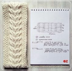 a knitted bookmark next to a notebook with instructions for knitting the cable on it