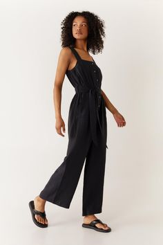 Self-tie belt cinches the waist
Wide leg cropped pants for a relaxed fit
Button front placket and patch pockets
Shoulder straps and square neckline
This effortless modal jumpsuit from Warehouse strikes the perfect balance between comfort and style. Designed with wide leg cropped pants and a button front placket, this versatile one-piece can be dressed up or down with ease. Cinch the waist with the self-tie belt for a flattering silhouette. Style with flat sandals for a casual daytime look, switching to wedges or heels for night. The square neckline and wide shoulder straps keep the focus on the relaxed, cropped fit. With its lightweight modal fabrication, this jumpsuit transitions seamlessly from season to season. Holiday Outfits Women, Utility Jumpsuit, Oasis Fashion, Wide Leg Cropped Pants, Airport Outfit, Wide Leg Jumpsuit, Black Jumpsuit, Fashion Face, Tie Belt