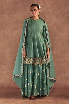 Moss green anarkali edged with kinari and embellished with border. Comes with irisbud foil printed sharara edged with kinari and a printed dupatta.
Components: 3
Pattern: Foil Printed, Embroidered
Type Of Work: Irisbud
Neckline: Round
Sleeve Type: Full
Fabric: Anarkali and Sharara- Raw Silk, Dupatta- Organza
Color: Green
Other Details: 
Disclaimer: The actual print-placement and colour of the product may vary slightly from the image shown.
Occasion: Sangeet - Aza Fashions Luxury Anarkali Slub Silk Sharara, Luxury Raw Silk Anarkali Sharara, Luxury Green Cotton Silk Sharara, Luxury Green Sharara With Bandhani Print, Green Raw Silk Anarkali Set For Reception, Designer Green Palazzo Set With Dupatta, Green Palazzo Set With Dupatta, Green Anarkali Palazzo Set With Zari Work, Designer Anarkali Palazzo Set In Green