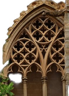 an ornate window in the side of a building with stone pillars and arched glass windows