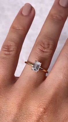 a woman's hand with a ring on it and a diamond in the middle