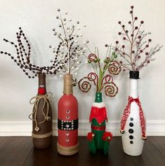 four wine bottles decorated with christmas decorations and candy canes are sitting on a table