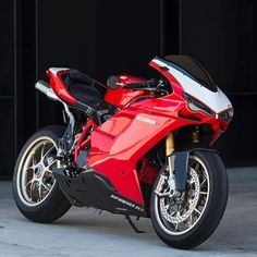 a red motorcycle parked in front of a building